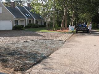 Failing asphalt driveway is removed and replaced with a cobble edged stone driveway.