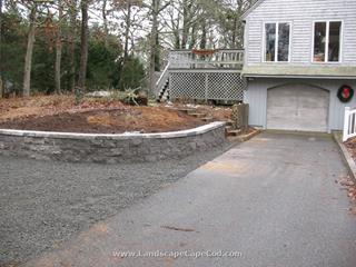 Driveway expansion with stone retaining block wall.