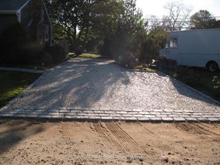 Cobblestone edging and apron set in concrete with shell driveway