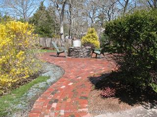 Antique red brick patio with a natural stone fire pit
